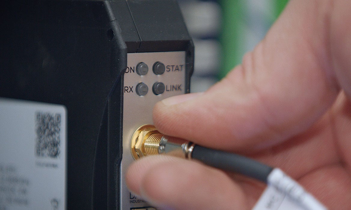 Hand verbindet Kabel mit Antenne – Antenneninstallation in der Antennentechnik